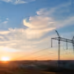 High voltage tower with electric power lines at sunset. Transmission of electricity.